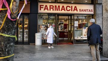 A pharmacist wears a mask as she speaks to a man keeping his distance, outside a pharmacy in Milan, Italy, Wednesday, March 11, 2020. Picture: Claudio Furlan