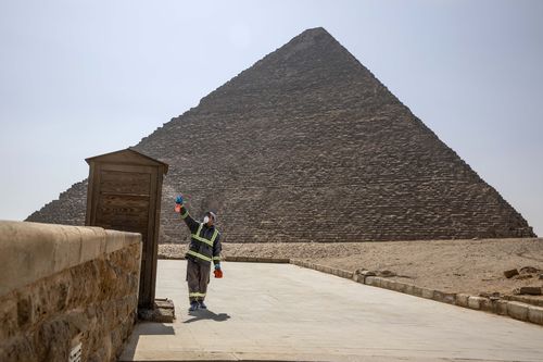 Municipal workers sanitize the areas surrounding the Giza pyramids complex in hopes of curbing the coronavirus outbreak in Egypt, Wednesday, March 25, 2020. 