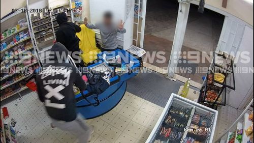 A store worker has been terrorised by machete-wielding robbers in a store.