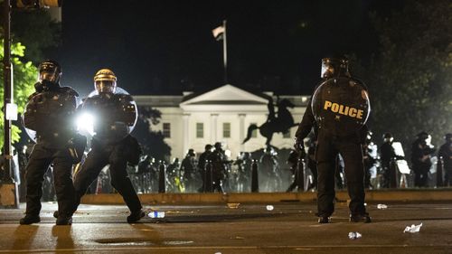 Police form a line on H Street as demonstrators gather near the White House.