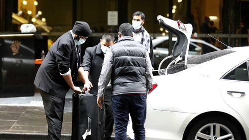 Guests at the Stamford Hotel in Melbourne are seen wearing masks as they get into taxis.