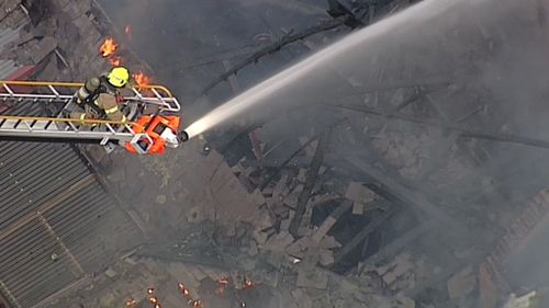 A firefighter attacks the fire from above. (9NEWS)