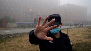 A security person moves journalists away from the Wuhan Institute of Virology after a World Health Organisation team arrived for a field visit in Wuhan in China&#x27;s Hubei province in February 2021.