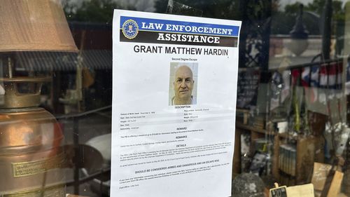 A flier looking for Grant Hardin hangs on the glass of a business, Thursday, May 29, 2025, in downtown Calico Rockt, Ark. (AP Photo/Nicholas Ingram)