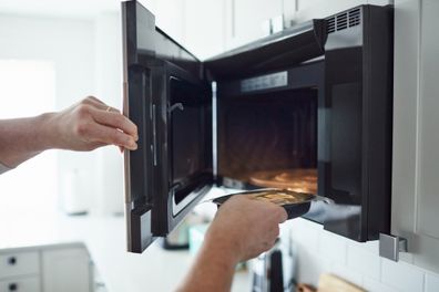 microwave meal going into microwave istock