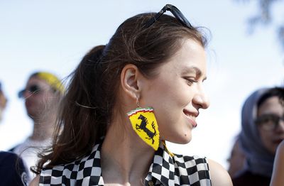 A woman with the Ferrari stable proudly shows off her Prancing Stallion earrings at the Melbourne Grand Prix. (AAP)