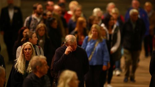 People react as they pay their respects passing the coffin of Britain's Queen Elizabeth ll, inside Westminster Hall on September 16, 2022 in London, England. Queen Elizabeth II's children mount a family vigil over her coffin lying in state in Westminster Hall. Queen Elizabeth II died at Balmoral Castle in Scotland on September 8, 2022, and is succeeded by her eldest son, King Charles III. (Photo by Hannah Mckay - WPA Pool / Getty Images)