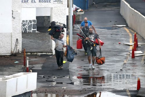 Residents take their belongings as they evacuate the apartment block in Mesa del Mar on Tenerife.