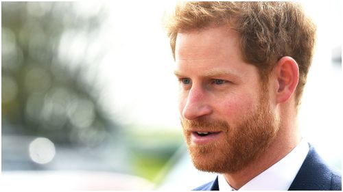 Prince Harry poses in front of an Apache helicopter after presenting Wings to graduates at the Museum of Army Flying in Middle Wallop (AAP)