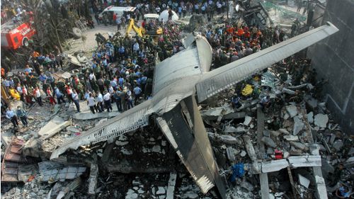 Rescuers search for victims at the site where an air force cargo plane crashed in Medan, North Sumatra. (AAP)