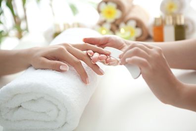 Close up of beautiful female hands having manicure treatment. 