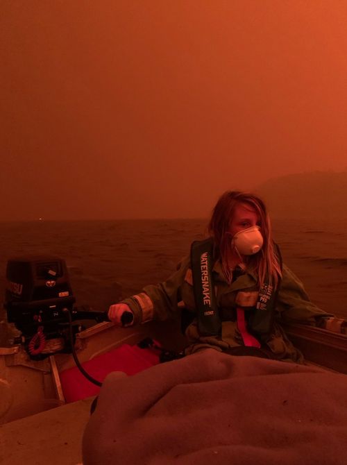 Finn Burns navigates a boat through thick smoke at Mallacoota, as fire advanced on the seaside Victorian town on December 31, 2019.