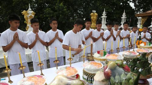 The boys exchanged their white clothing for traditional orange robes before praying with guests. Picture: AP