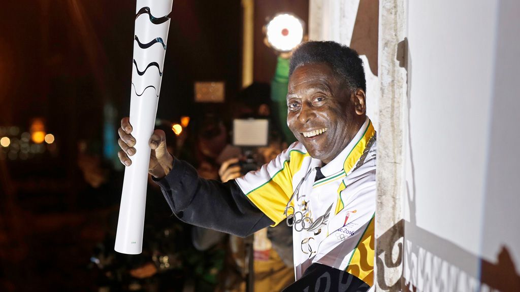 Former football player Pele holding the Olympic flame at the Pele Museum in Santos, Sao Paulo State, on July 22, 2016. (AFP)