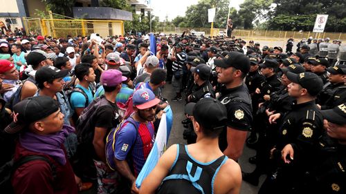 several Guatemalan police officers and migrants were injured as the group kicked and pushed its way through the gate on the Guatemalan side of the border. 