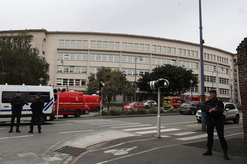 Police officer guard the highschool after a man armed with a knife killed a teacher and wounded two others at a high school in northern France, Friday, Oct. 13, 2023 in Arras. 