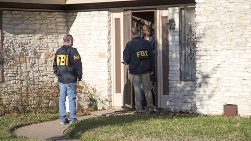 Officers are seen at a home in East Austin, after a teenager was killed and a woman was injured today (AAP)