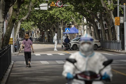 Des policiers en équipement de protection individuelle (EPI) vérifient les documents des navetteurs lors d'un verrouillage à Shanghai, en Chine, le jeudi 28 avril 2022. Shanghai, qui est devenue le plus grand point chaud de la pire épidémie de Chine depuis l'apparition du virus à Wuhan, a a enduré un mois de confinement qui a maintenu la plupart des 25 millions d'habitants de la ville confinés chez eux.  Source : Bloomberg