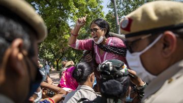 An Indian activist shouts slogans as she is detained by police during a protest in New Delhi.