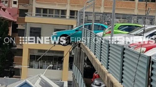 Car dangles over edge of high-rise car park at Brisbane hospital
