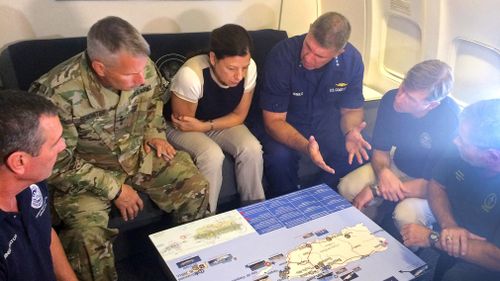 Acting Homeland Secretary Elaine Duke, center, is briefed on the Hurricane Maria response during a flight to Puerto Rico. (AP)