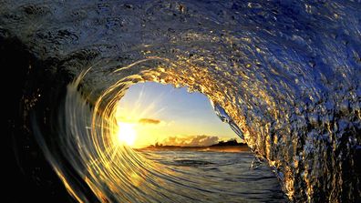 In this undated photo entitled &quot;Sun Curl,&quot; the rising sun is framed by a breaking wave on the North Shore of Oahu near Haleiwa, Hawaii. The image appears in photographer Clark Little&#x27;s new book, &quot;The Art of Waves.&quot;  