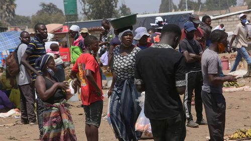 People are seen at a busy market in a poor township on the outskirts of the capital Harare in Zimbabwe.