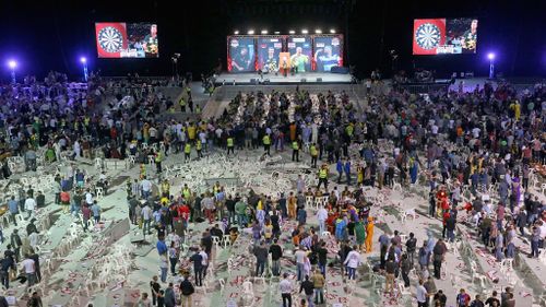 Security guards surround a pile of tables and chairs thrown by spectators at the Invitational Darts Challenge in Melbourne. (Getty)