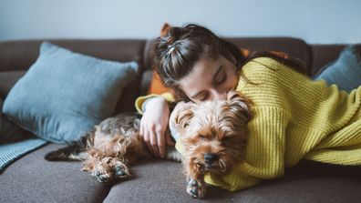 Woman hugging her dog on the couch