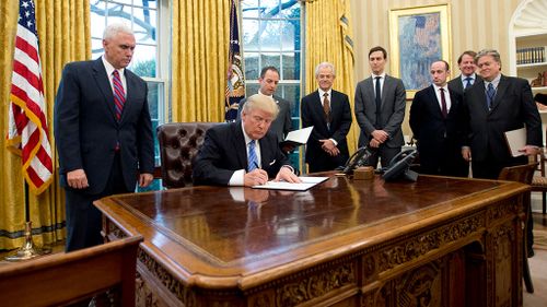 Trump signs executive order on abortion surrounded by men