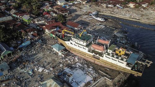 The impact of the earthquake and tsunami from above shows a ship dragged inland.