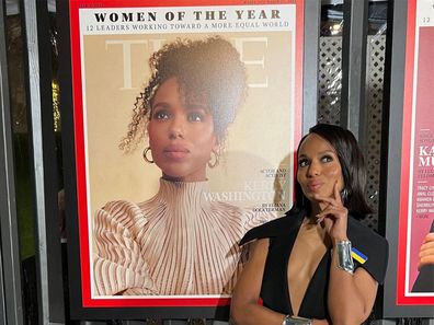 Kerry Washington posing next to an enlarged photo her featured on a TIME magazine cover.