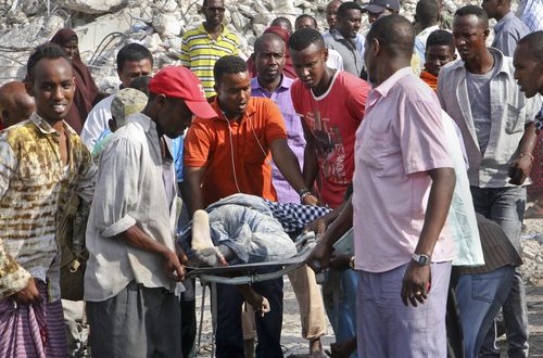 Somalis remove the body of  a man killed in the blast. (AP)