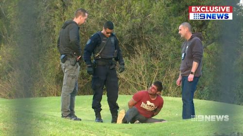 The man was handcuffed on the grass while his face was bleeding and as he grimaced in pain. Picture: 9NEWS