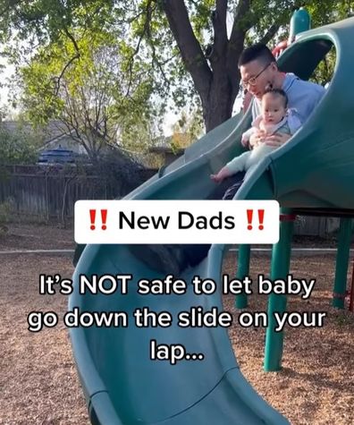 Dad going down slide with baby. 