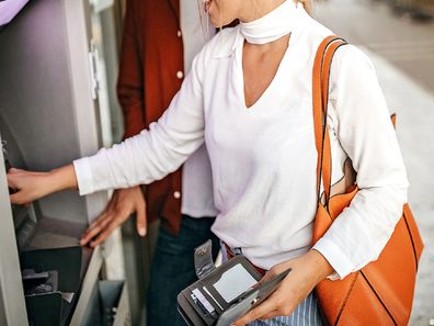 Young woman withdrawing money from ATM