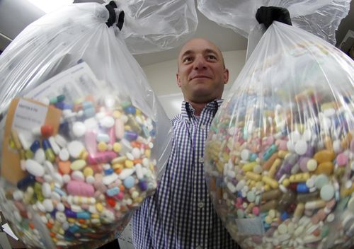 Narcotics detective Ben Hill, with the Barberton Police Department, shows two bags of medications that are are stored in their headquarters and slated for destruction, in Barberton, Pennsylvania.