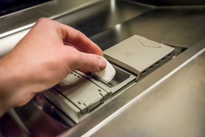 Putting the dishwasher tablet in the dispenser