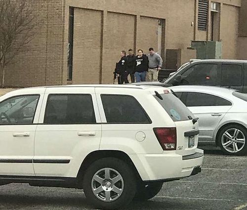 Police escort a 15-year-old student, second from right, out of the Marshall County High School after the shooting. (AAP)
