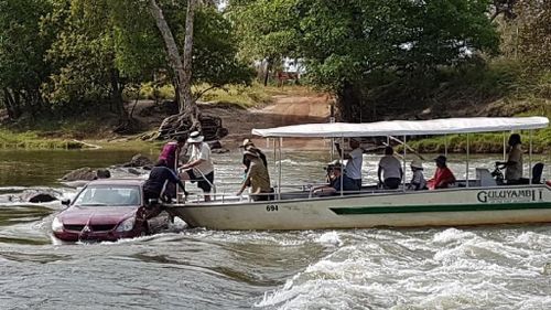 The pair became trapped in floodwaters before a tourist boat spotted them, helped them jump from the vehicle and police arrived, on the lookout for nearby crocodiles. Picture: Reijo Keitaanpaa. 