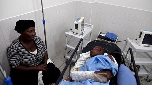  man injured in a bus crash is accompanied by his relatives at the hospital of Gonaives. (AAP)
