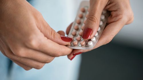 Close-up of woman holding a contraceptive pills. Concept of contraception methods.