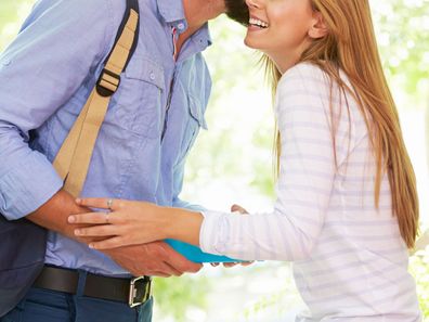 Man kissing woman goodbye.