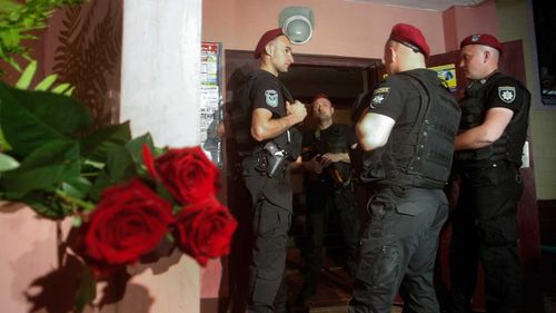 Ukrainian policemen guard an entrance to the home of Russian opposition journalist Arkady Babchenko in Kiev, Ukraine. (AAP)