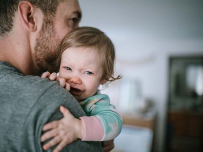 Father holding crying baby