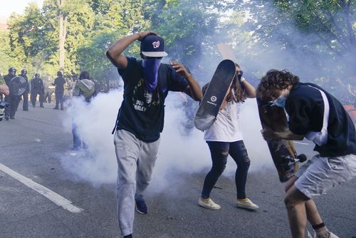 Demonstrators, who had gathered to protest the death of George Floyd, run from tear gas used by police to clear the street near the White House in Washington