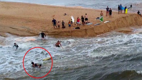 A group of Dee Why surfers have been hailed "heroes" after saving a man being swept out to sea during the city's wild weather.