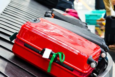 Luggages moving on airport conveyor belt. suitcase with ribbon