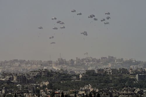 An aircraft airdrops humanitarian aid over the northern Gaza Strip, as seen from southern Israel, on Sunday.