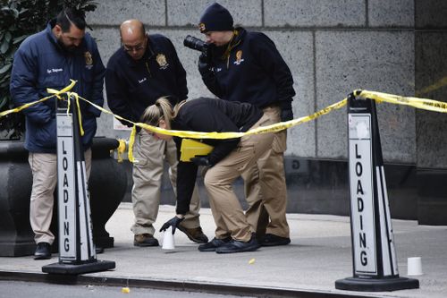 Detectives at the scene in Manhattan where Brian Thompson was shot